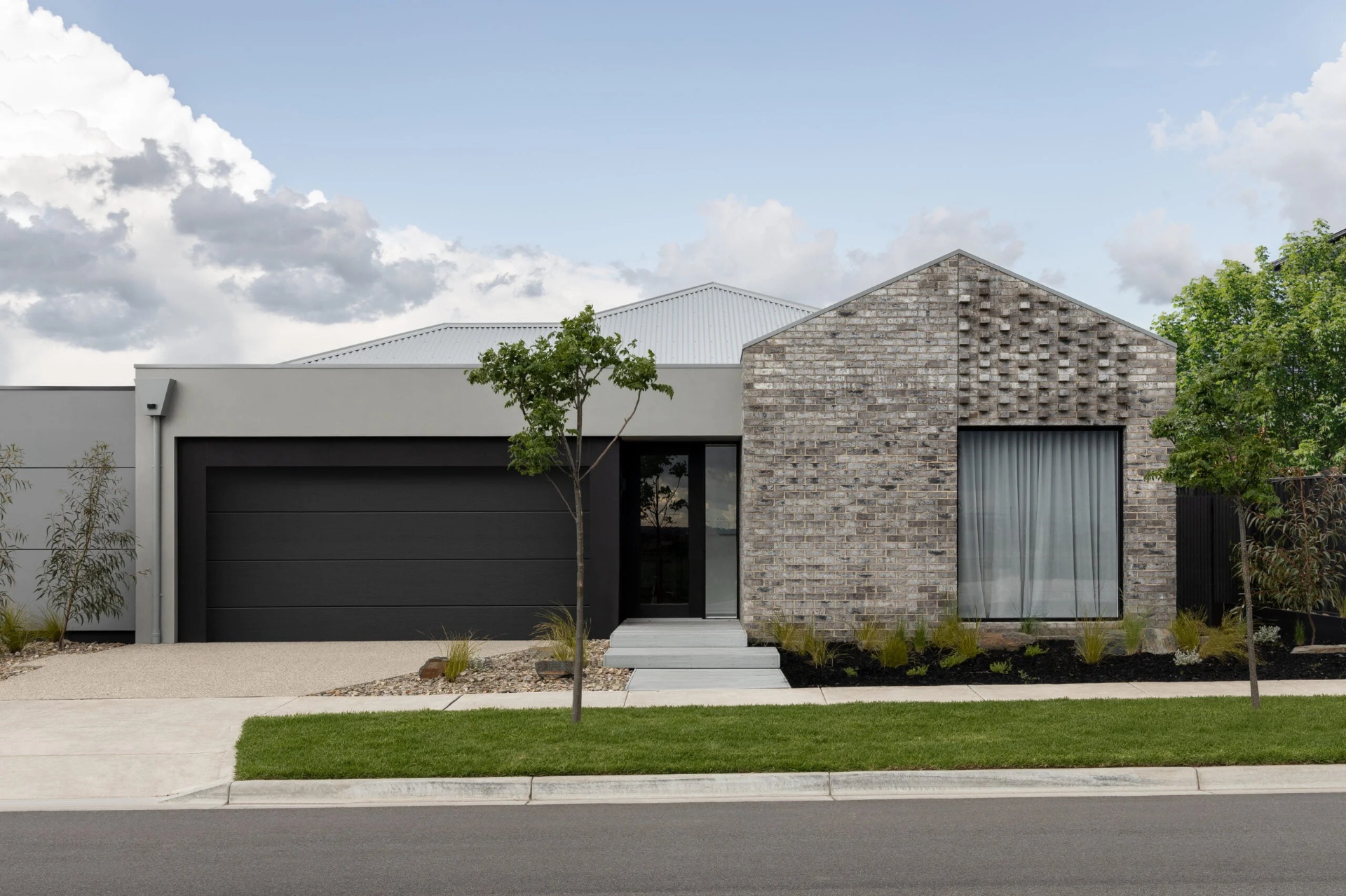 Completed turn-key Melbourne house and land package with modern brick facade and dark garage door